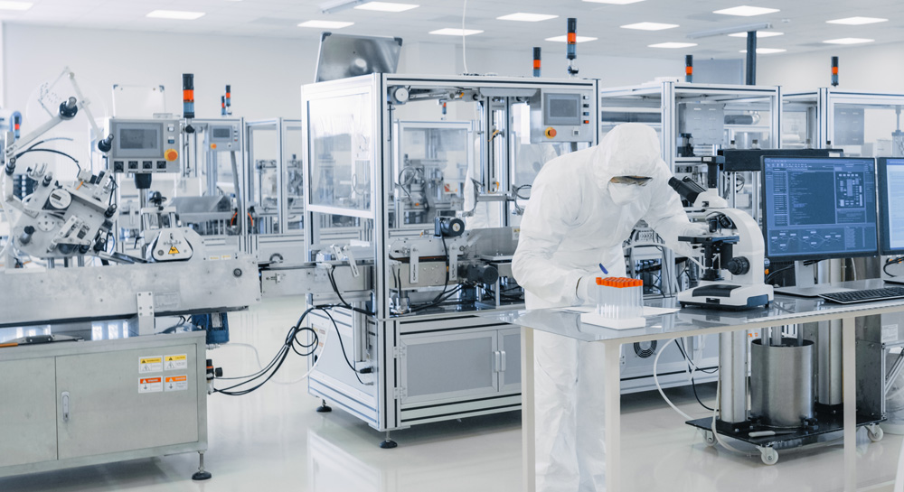 Shot of Sterile Pharmaceutical Manufacturing Laboratory where Scientists in Protective Coverall's Do Research