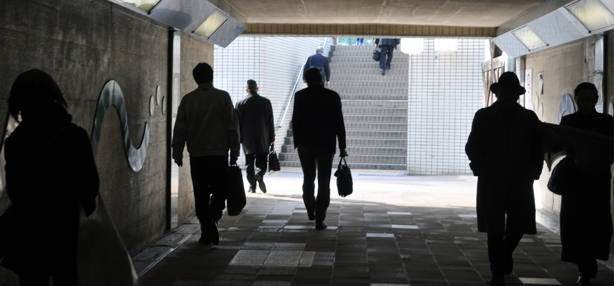 A group of people walking towards a subway exit