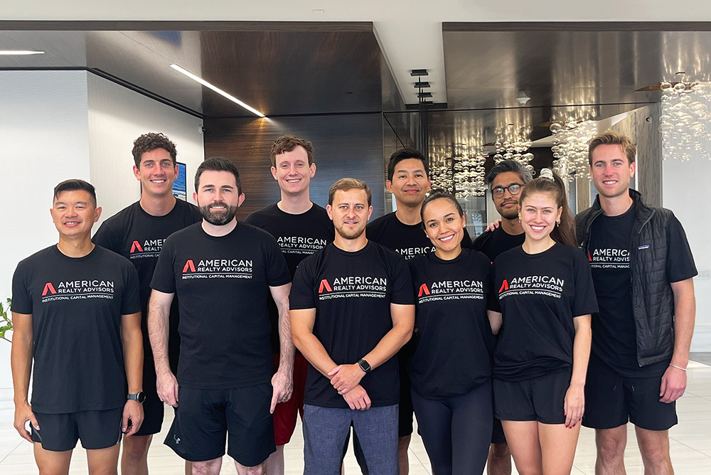 An ARA employee standing in front of a stack of donated wrapped gifts