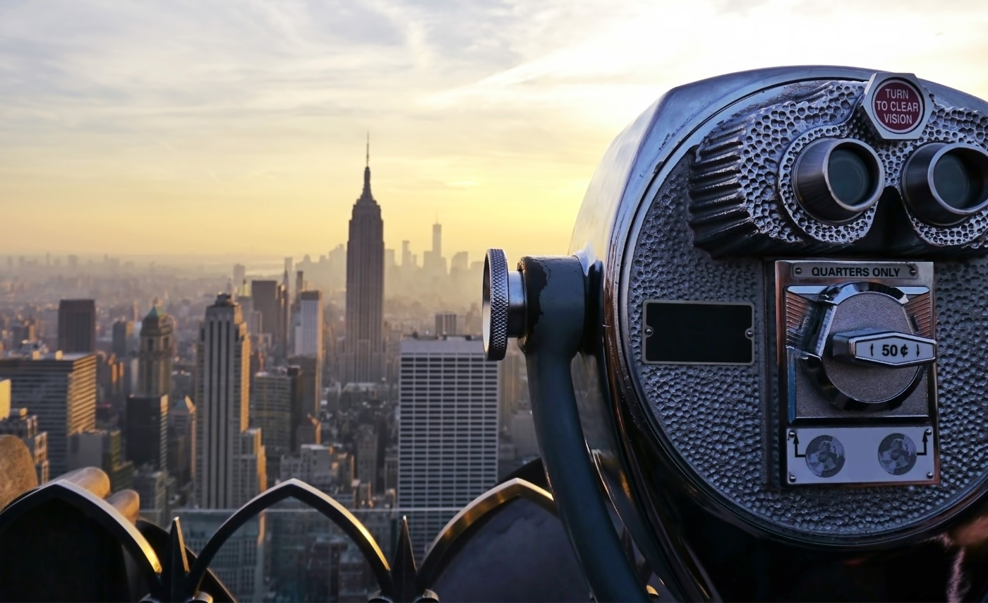 An observation device aimed at a downtown city skyline in the background