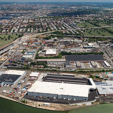 Aerial view of industrial warehouses by a river and bridge