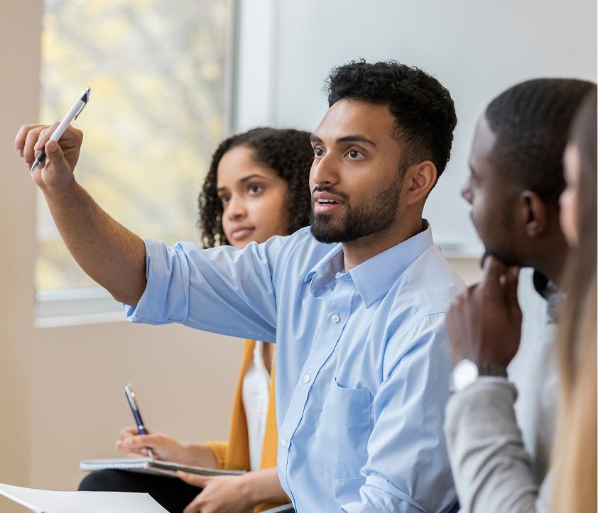 Man raising a pen during discussion with peers beside him