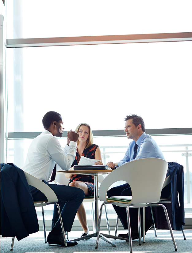 Three colleagues in discussion at a table