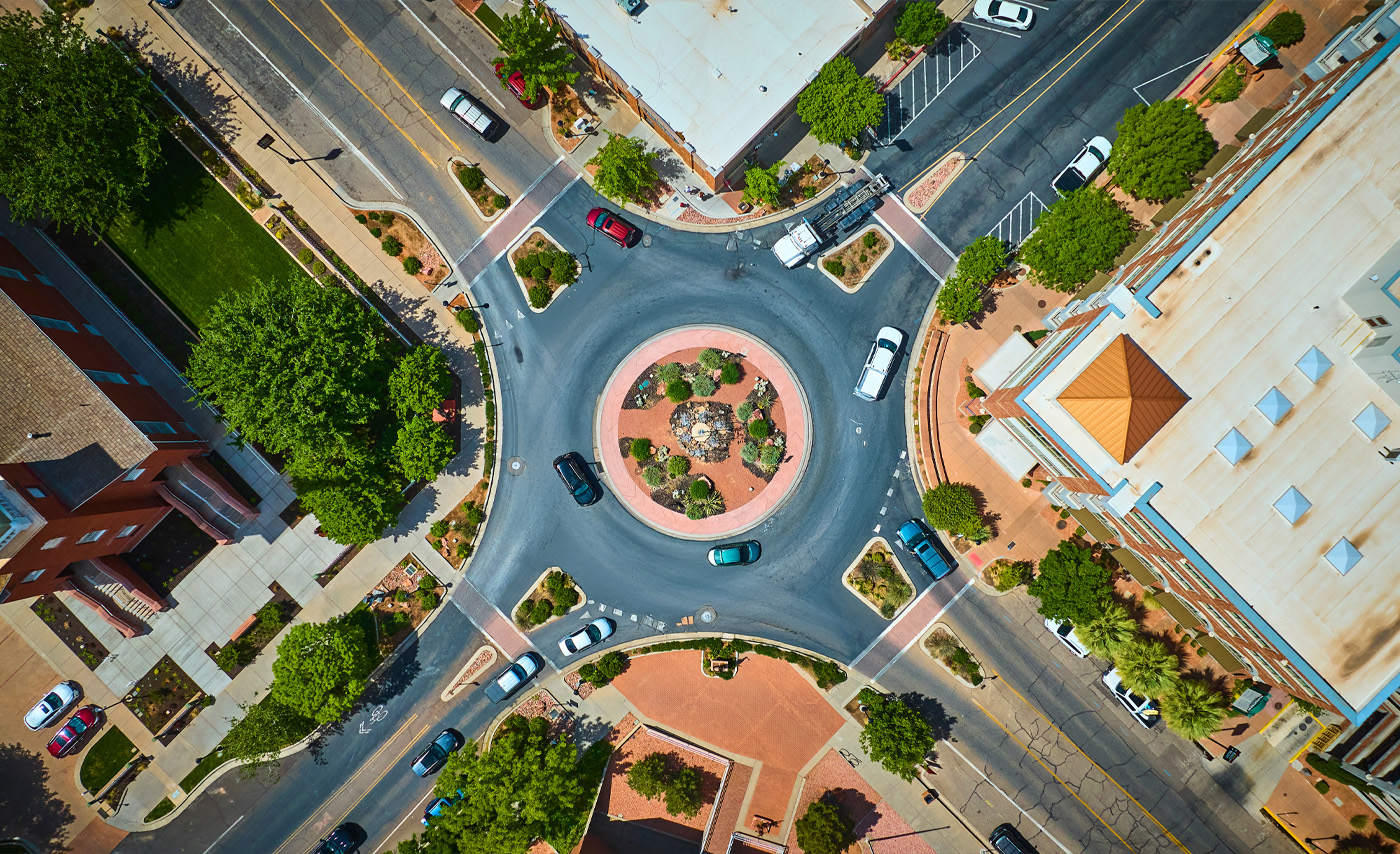 Cars driving around a roundabout street in a city